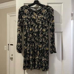 A yellow, white, black dress, that is long sleeve and lightly worn